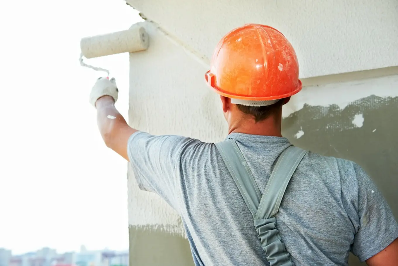 budowlaniec nakłada farbę termiczną na ścianę